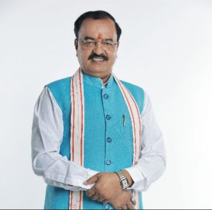 उत्तर प्रदेश के एक वरिष्ठ राजनीतिक नेता का औपचारिक चित्र, जो सफेद कुर्ते और नीले रंग की जैकेट पहने हुए हैं।